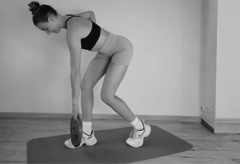 Anna beim Krafttraining mit einer Gewichtsscheibe